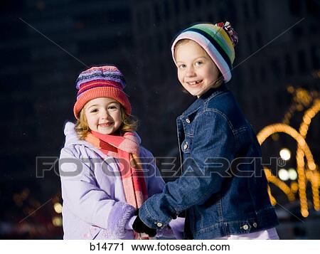Stock Image - Two girls outdoors in winter smiling. Fotosearch