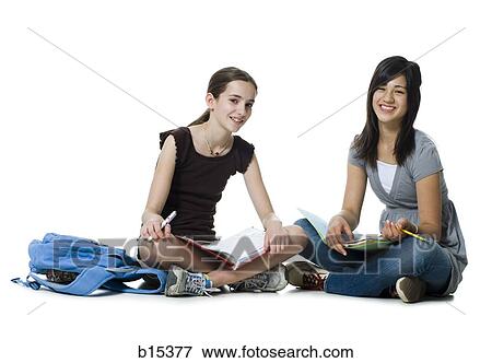 Two girls sitting cross legged doing homework View Large Photo Image Stock Photo - Two girls sitting cross legged doing homework. Fotosearch