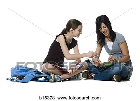 Two girls sitting cross legged doing homework View Large Photo Image Stock Photo - Two girls sitting cross legged doing homework. Fotosearch