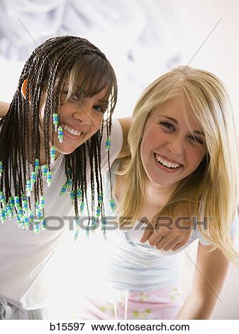 Two girls smiling and hugging View Large Photo Image Stock Photo - Two girls smiling and hugging. Fotosearch