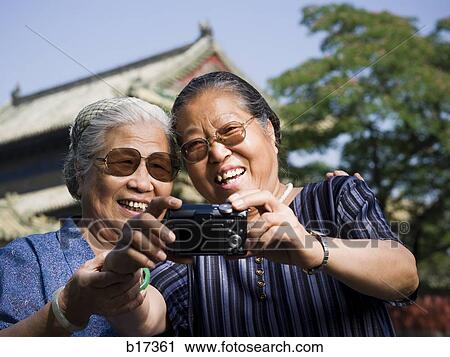 Two women embracing outdoors with camera View Large Photo Image Stock Image - Two women embracing outdoors with camera. Fotosearch
