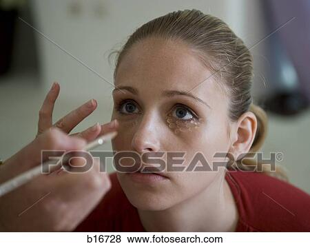 Woman applying makeup to woman's eyes View Large Photo Image Stock Photo - Woman applying makeup to woman's eyes. Fotosearch