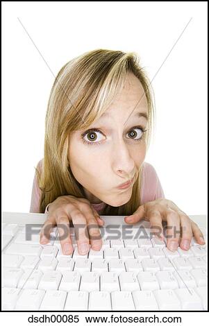 Woman at keyboard looking perplexed View Large Photo Image Stock Photography - Woman at keyboard looking perplexed. Fotosearch