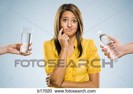 Woman choosing between glass of water and bottled water View Large Photo Image Stock Image - Woman choosing between glass of water and bottled water. Fotosearch