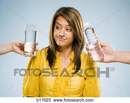 Woman choosing between glass of water and bottled water View Large Photo Image Stock Image - Woman choosing between glass of water and bottled water. Fotosearch