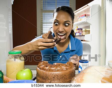 Woman devouring chocolate cake from refrigerator View Large Photo Image Picture - Woman devouring chocolate cake from refrigerator. Fotosearch