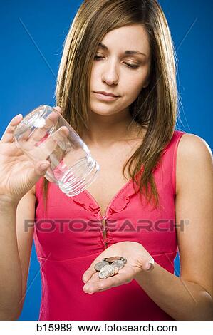 Woman emptying coins from jar into hand View Large Photo Image Stock Photo - Woman emptying coins from jar into hand. Fotosearch