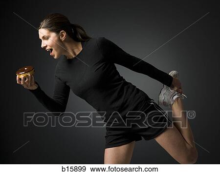 Woman holding a donut and stretching View Large Photo Image Stock Photo - Woman holding a donut and stretching. Fotosearch