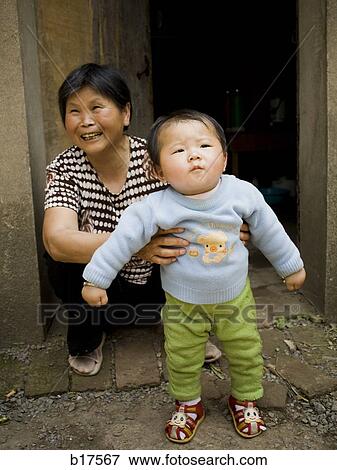 Woman holding baby outdoors View Large Photo Image Stock Photo - Woman holding baby outdoors. Fotosearch