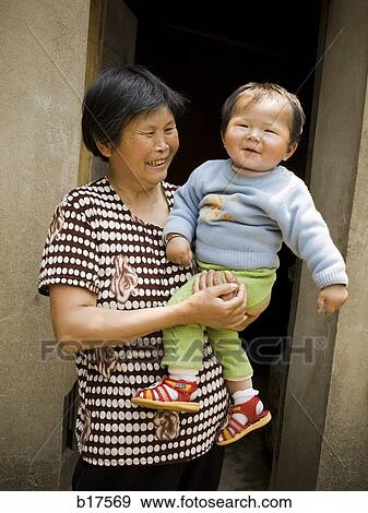 Woman holding baby outdoors View Large Photo Image Stock Photo - Woman holding baby outdoors. Fotosearch