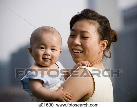 Woman holding baby smiling View Large Photo Image Stock Image - Woman holding baby smiling. Fotosearch
