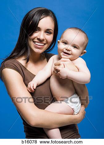 Woman holding baby smiling View Large Photo Image Stock Photo - Woman holding baby smiling. Fotosearch