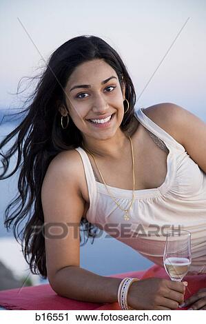 Woman holding champagne flute and reclining outdoors View Large Photo Image Stock Image - Woman holding champagne flute and reclining outdoors. Fotosearch