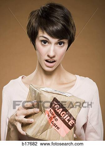 Woman holding crushed cardboard box with fragile label View Large Photo Image Stock Image - Woman holding crushed cardboard box with fragile label. Fotosearch
