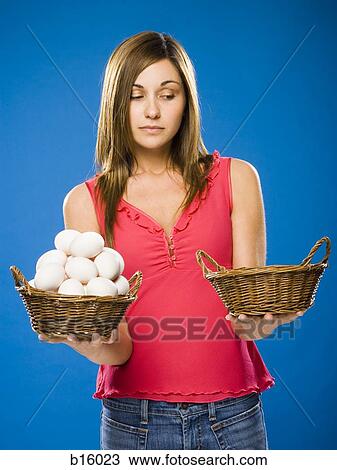 Woman holding empty basket and basket filled with eggs View Large Photo Image Stock Image - Woman holding empty basket and basket filled with eggs. Fotosearch