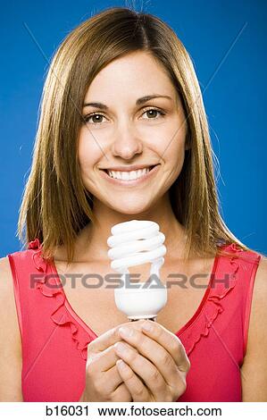 Woman holding energy efficient lightbulb smiling View Large Photo Image Stock Image - Woman holding energy efficient lightbulb smiling. Fotosearch