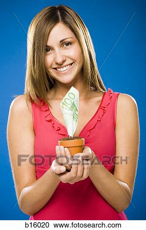 Stock Image - Woman holding euro money tree. Fotosearch