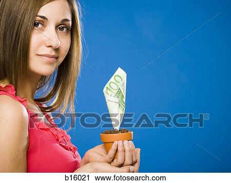Stock Image - Woman holding euro money tree. Fotosearch