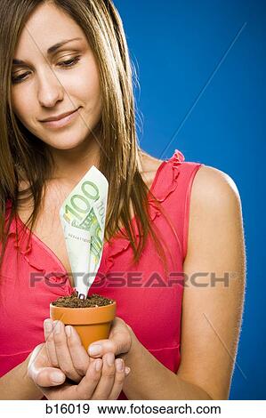 Woman holding euro money tree View Large Photo Image Stock Photo - Woman holding euro money tree. Fotosearch