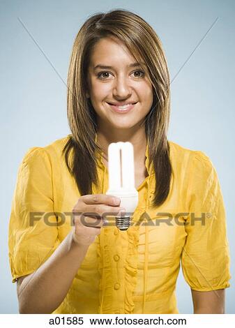 Woman holding fluorescent light bulb smiling View Large Photo Image Stock Photography - Woman holding fluorescent light bulb smiling. Fotosearch