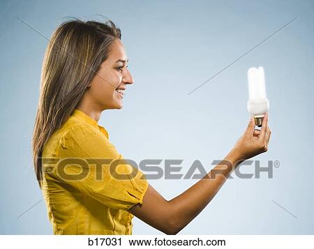 Woman holding fluorescent lightbulb View Large Photo Image Stock Image - Woman holding fluorescent lightbulb. Fotosearch