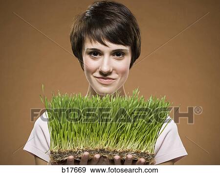 Woman holding grass and smiling View Large Photo Image Stock Photo - Woman holding grass and smiling. Fotosearch