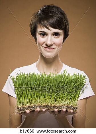Woman holding grass smiling View Large Photo Image Stock Photograph - Woman holding grass smiling. Fotosearch