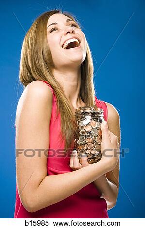 Woman holding jar filled with coins smiling View Large Photo Image Stock Photography - Woman holding jar filled with coins smiling. Fotosearch
