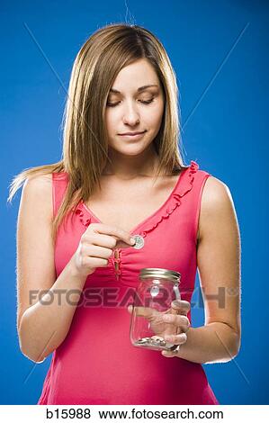 Woman holding nearly empty jar with coins View Large Photo Image Stock Photo - Woman holding nearly empty jar with coins. Fotosearch