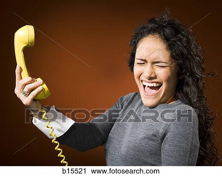 Woman holding retro phone and yelling View Large Photo Image Stock Image - Woman holding retro phone and yelling. Fotosearch