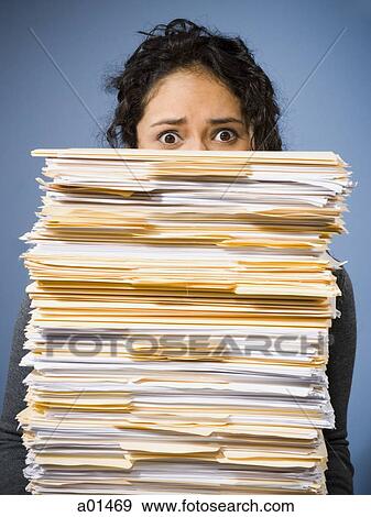 Woman holding stacks of paperwork View Large Photo Image Stock Photo - Woman holding stacks of paperwork. Fotosearch
