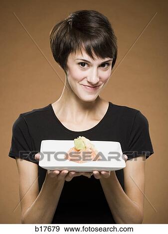 Stock Photo - Woman holding sushi smiling. Fotosearch