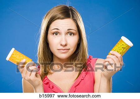 Woman holding two bottles of prescription capsules View Large Photo Image Stock Photo - Woman holding two bottles of prescription capsules. Fotosearch