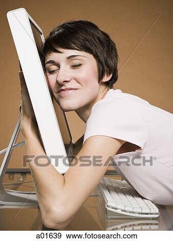 Woman hugging computer monitor smiling View Large Photo Image Stock Photo - Woman hugging computer monitor smiling. Fotosearch