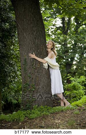 Woman hugging tree outdoors with eyes closed View Large Photo Image Stock Photo - Woman hugging tree outdoors with eyes closed. Fotosearch