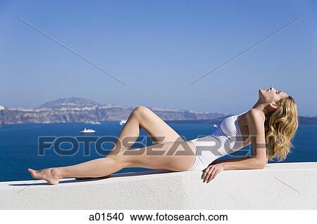 Woman in bathing suit reclining outdoors View Large Photo Image Stock Image - Woman in bathing suit reclining outdoors. Fotosearch