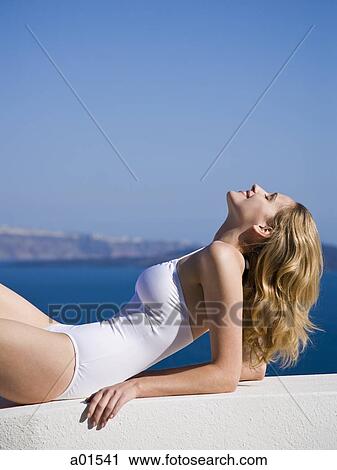 Woman in bathing suit reclining outdoors View Large Photo Image Stock Image - Woman in bathing suit reclining outdoors. Fotosearch