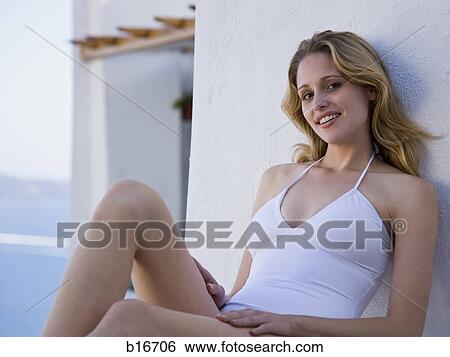 Woman in bathing suit sitting outdoors leaning on wall smiling View Large Photo Image Stock Photograph - Woman in bathing suit sitting outdoors leaning on wall smiling. Fotosearch