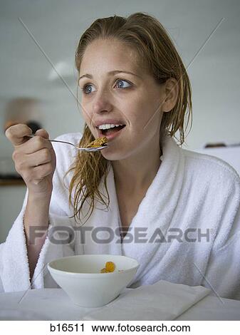 Woman in bathrobe eating cereal View Large Photo Image Stock Image - Woman in bathrobe eating cereal. Fotosearch