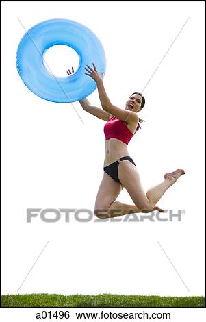 Woman in bikini jumping and smiling with swimming ring View Large Photo Image Stock Photograph - Woman in bikini jumping and smiling with swimming ring. Fotosearch