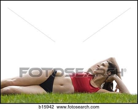 Woman in bikini lying down in grass View Large Photo Image Stock Image - Woman in bikini lying down in grass. Fotosearch