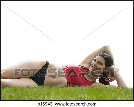 Woman in bikini lying down in grass View Large Photo Image Stock Image - Woman in bikini lying down in grass. Fotosearch