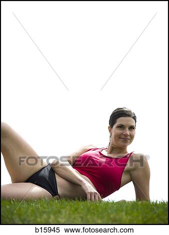 Woman in bikini lying down in grass View Large Photo Image Stock Photography - Woman in bikini lying down in grass. Fotosearch
