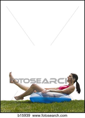 Woman in bikini lying in swimming ring laughing View Large Photo Image Stock Photo - Woman in bikini lying in swimming ring laughing. Fotosearch