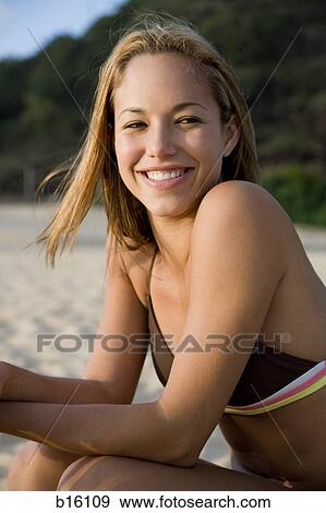 Stock Photo - Woman in bikini on beach smiling. Fotosearch