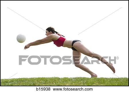 Woman in bikini playing volleyball outdoors on grass View Large Photo Image Stock Photo - Woman in bikini playing volleyball outdoors on grass. Fotosearch