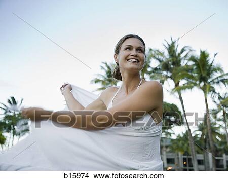 Woman in bikini with wrap smiling with arms up outdoors View Large Photo Image Picture - Woman in bikini with wrap smiling with arms up outdoors. Fotosearch