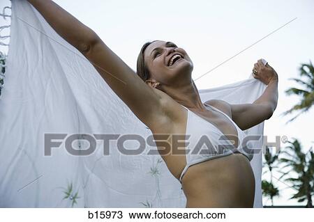 Woman in bikini with wrap smiling with arms up outdoors View Large Photo Image Stock Image - Woman in bikini with wrap smiling with arms up outdoors. Fotosearch