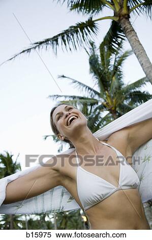 Woman in bikini with wrap smiling with arms up outdoors View Large Photo Image Stock Photography - Woman in bikini with wrap smiling with arms up outdoors. Fotosearch