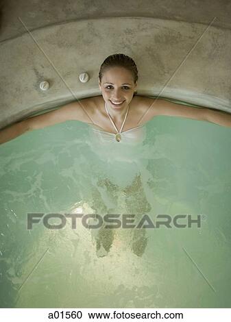 Stock Image - Woman in hot tub smiling. Fotosearch